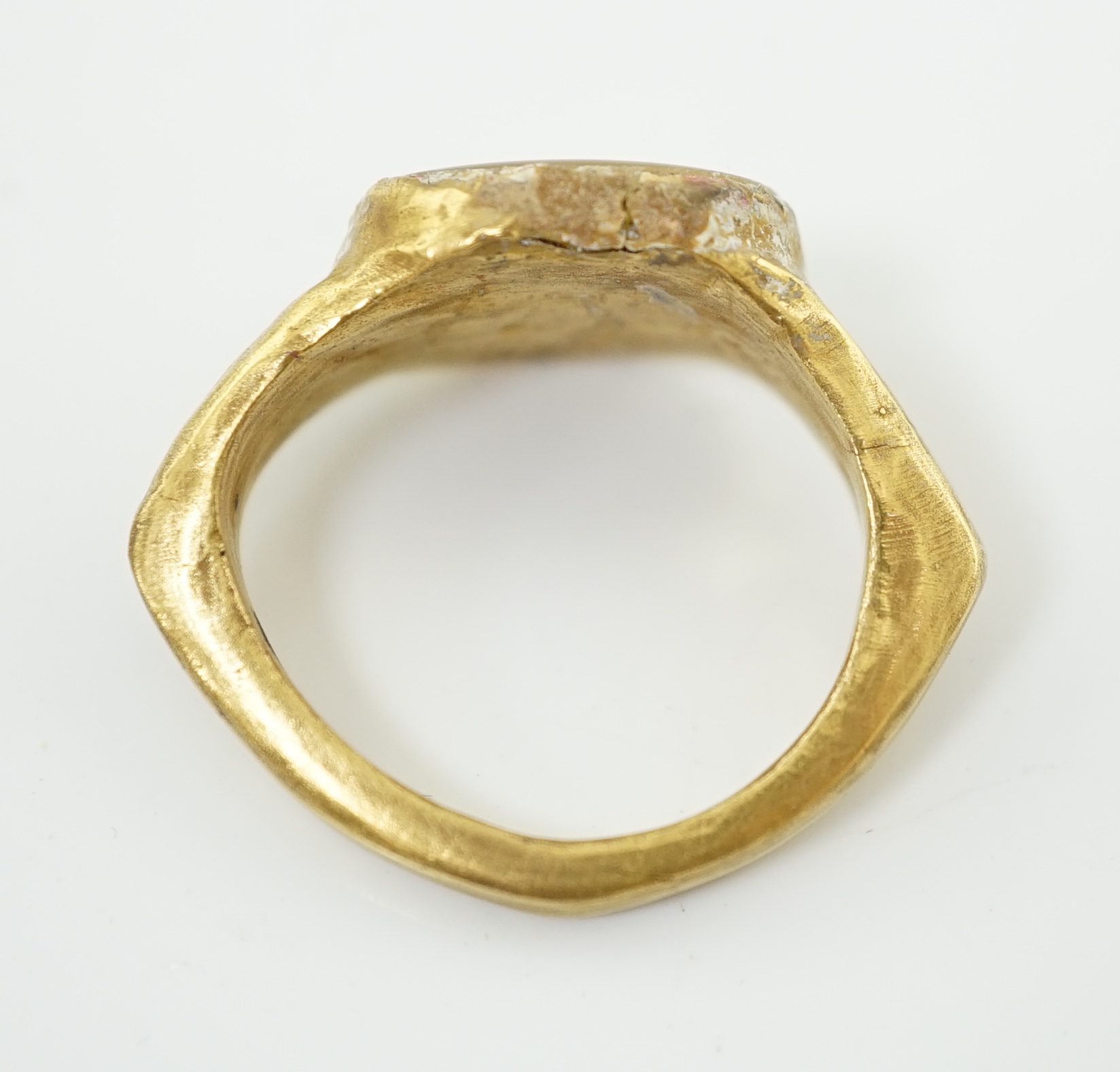 A Roman gold and hardstone intaglio military finger ring, carved with Saturn beside a pedestal